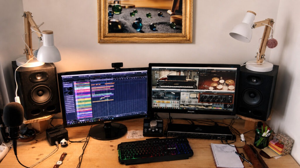 Home studio avec écran de production audio, enceintes et casque, illustrant les services de production musicale de SILAB.